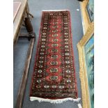 A Bokhara style red ground rug, 190 x 62cm