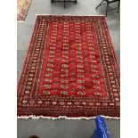 A Bokhara style red ground carpet, 280cm x 188cm