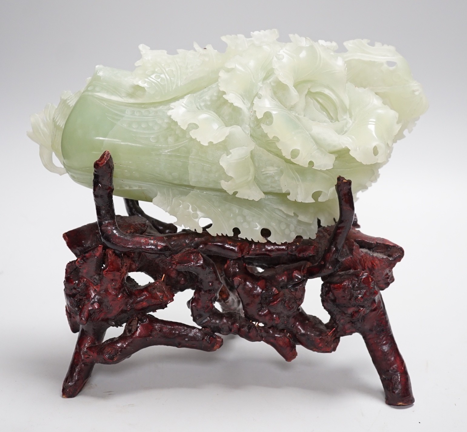 A Chinese bowenite jade carving of a cabbage and a rootwood stand, overall height 24cm