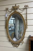 An Edwardian Adam-design oval giltwood and composition wall mirror, width 41cm, height 76cm