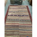 An antique polychrome flatweave carpet (cut centrally and re-stitched), 284 x 163cm