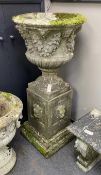 A reconstituted stone campana garden urn on lion mask plinth, diameter 60cm, height 130cm