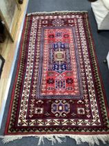 A Caucasian style red ground rug, 190 x 102cm