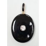 A Victorian yellow metal mounted black onyx oval locket, with black enamelled bale and set with an