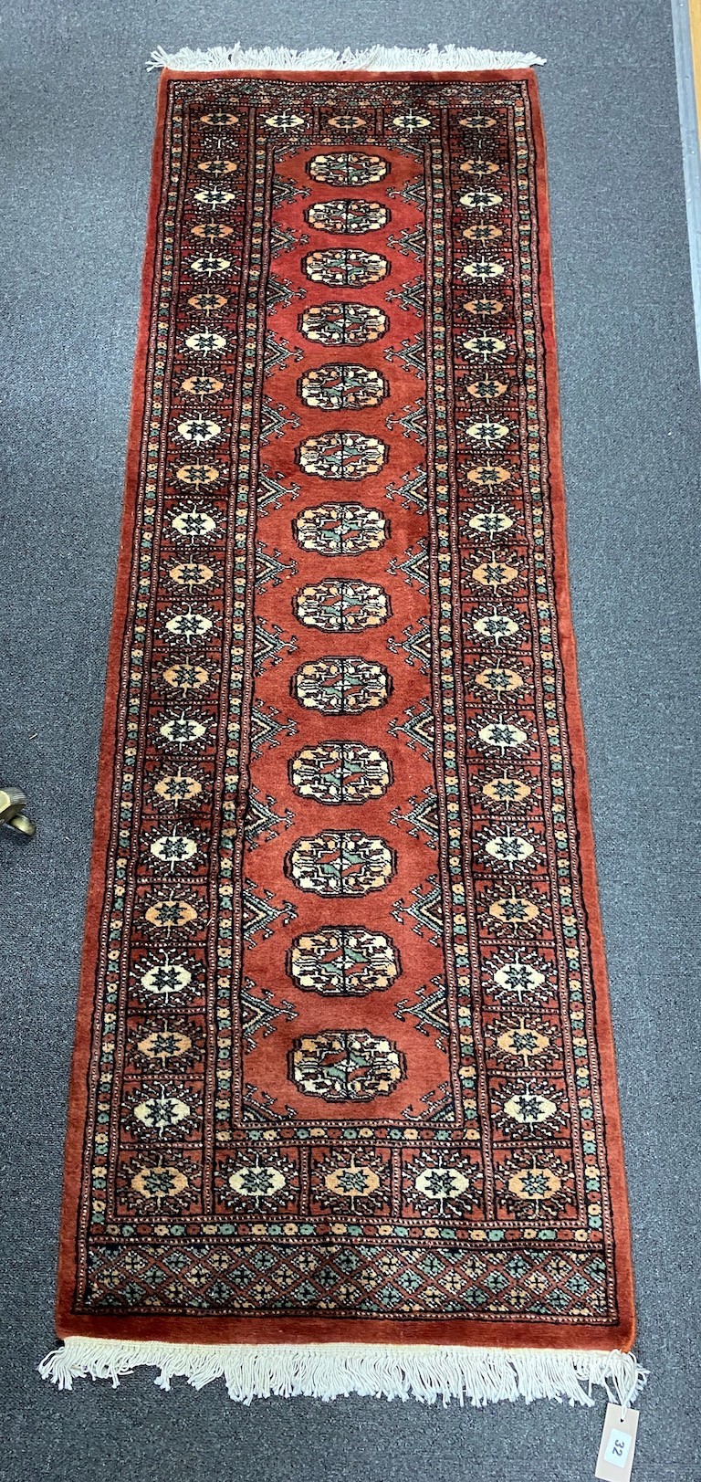 A Bokhara style red ground rug, 190 x 62cm - Image 3 of 3