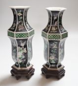 A pair of Chinese famille noire hexagonal vases, late 19th century, wood stands, 21cms high