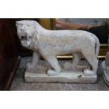 A South East Asian carved stone standing lion, width 60cm, height 50cm