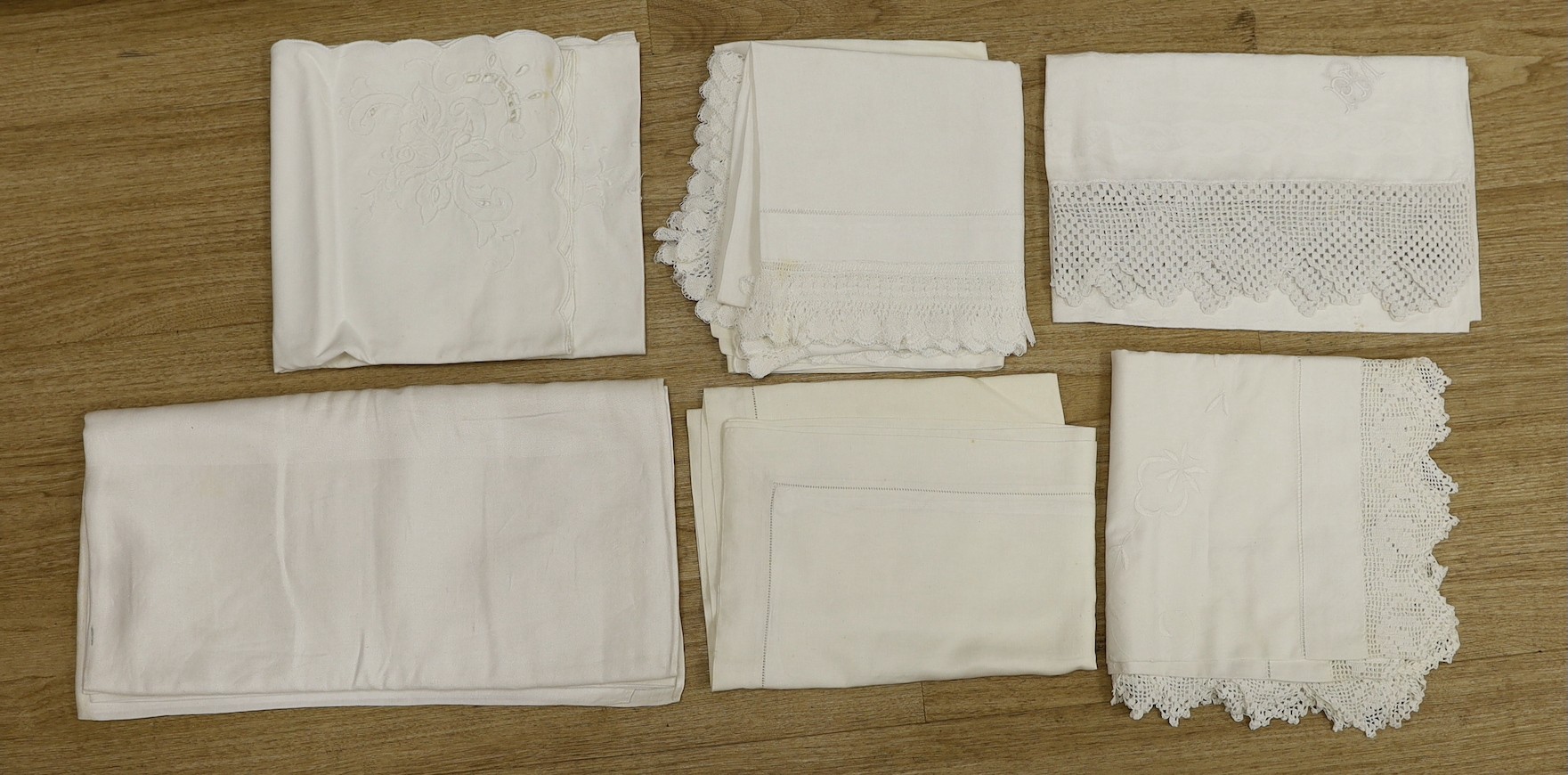 A quantity of lace trimmed and embroidered fabrics including tray cloths and pillow cases