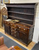 A mid 18th century oak dresser, fitted over with an open boarded rack, the latter reduced in height,