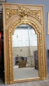 A Victorian pitch pine and gilt composition wall mirror the arched plate with floral vase