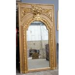 A Victorian pitch pine and gilt composition wall mirror the arched plate with floral vase