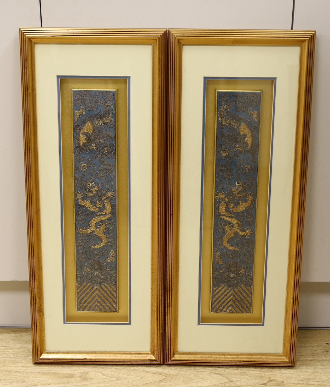 A pair of framed early 20th century Chinese metal thread embroidered ‘dragon’ design sleeve bands,