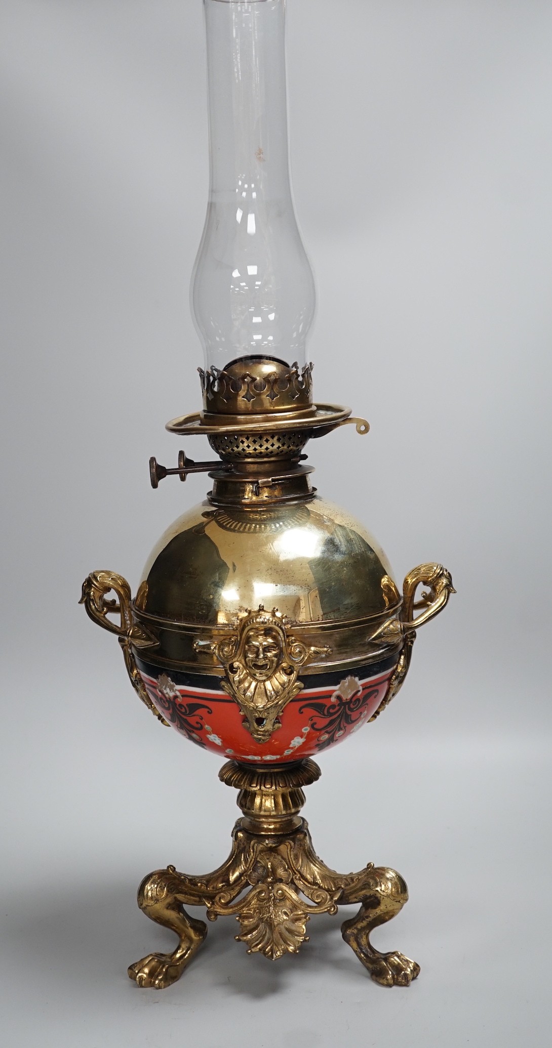 An early 20th century brass and porcelain oil lamp, 60cm total height