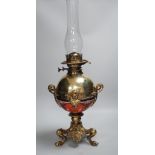 An early 20th century brass and porcelain oil lamp, 60cm total height