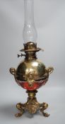 An early 20th century brass and porcelain oil lamp, 60cm total height