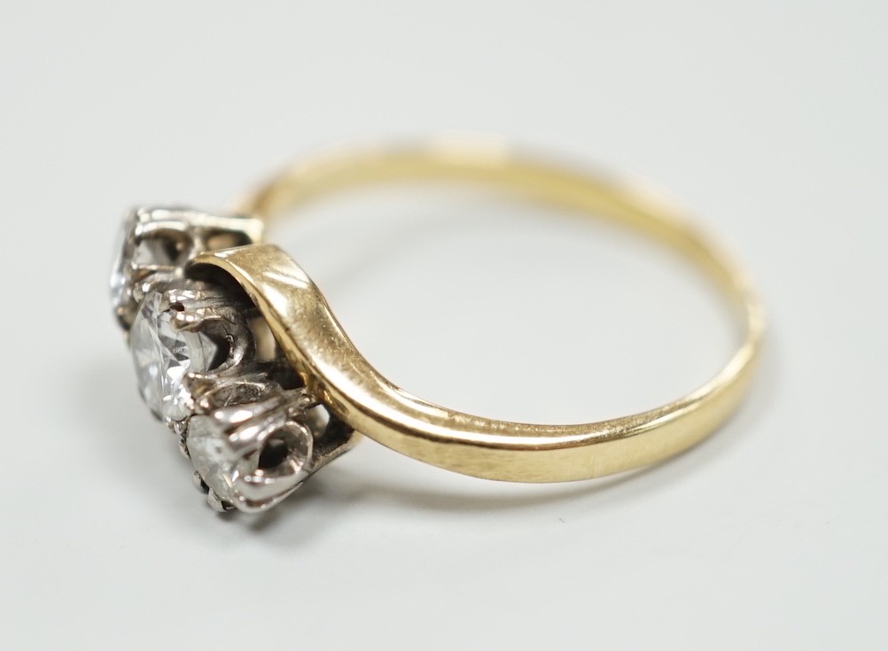 A yellow metal and three stone diamond set crossover ring, size K, gross weight 2.1 grams, the - Image 2 of 3