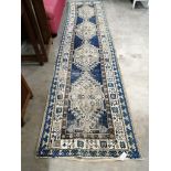 An antique Caucasian blue ground runner, worn, 370 x 90cm