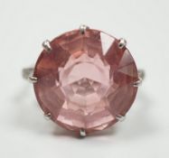 A white metal and circular cut pink topaz set dress ring, with three stone graduated diamond set