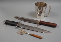 Two Bowie knives and a mug and a fork