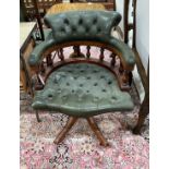 A reproduction buttoned green leather mahogany swivel desk chair, width 62cm, depth 56cm, height