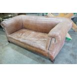 An early 20th century tan leather drop arm Chesterfield settee, width 160cms, depth 84cms, height