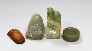 A Chinese green jade 'cash' wheel and a russet jade cicada, a jade pebble carving and a hardstone