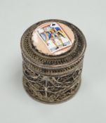 A continental filigree white metal and enamelled cylindrical pill box, the cover enamelled with a