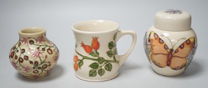 Three boxed Moorcroft pieces; Rose Hip cup, Butterfly jar and cover, and a Fuchsia vase, tallest