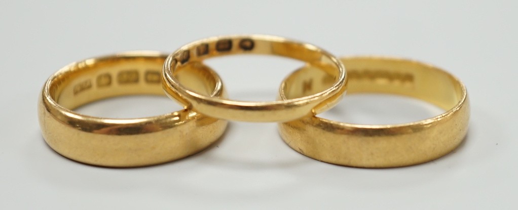 A thin Victorian 22ct gold wedding band, London, 1875, size K/L and two later 22ct gold wedding