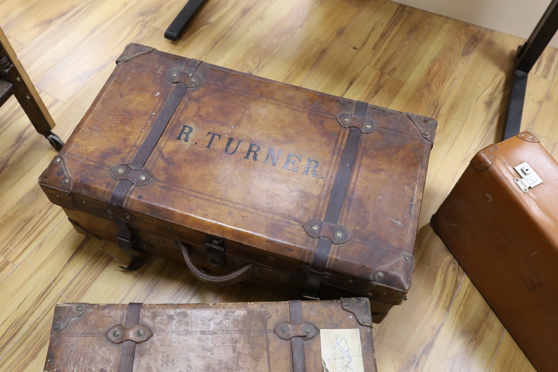 Three early 20th century brown leather cabin trunks and a later vintage suitcase, largest trunk - Image 4 of 4