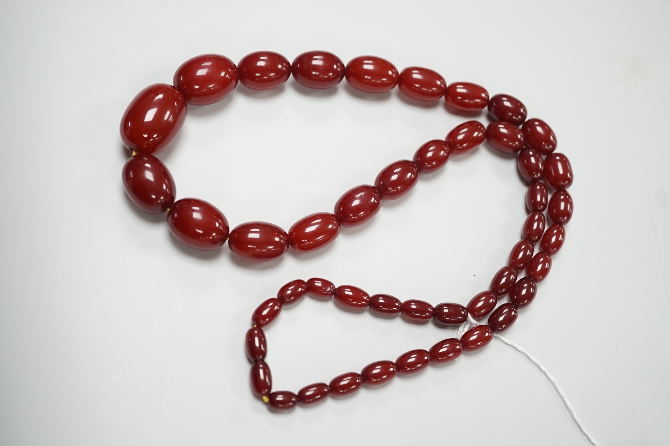 A single strand graduated simulated oval cherry amber necklace, 82cm, gross weight 113 grams. - Image 2 of 4