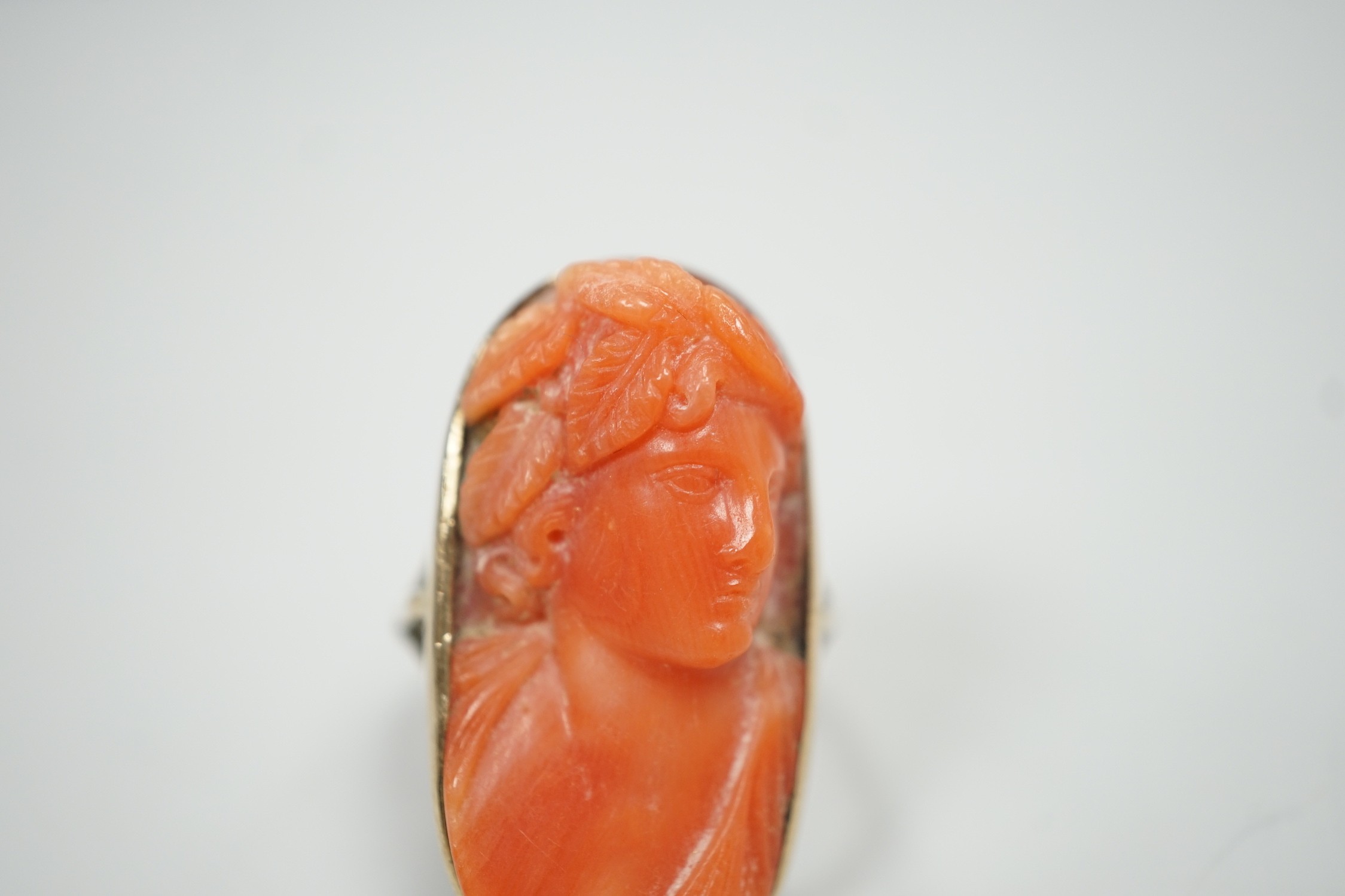 A yellow metal and coral set oval dress upfinger ring, the coral carved with a classical bust to - Image 2 of 6