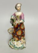 A Derby porcelain figure, emblematic of Summer, modelled as a woman wearing a floral patterned skirt