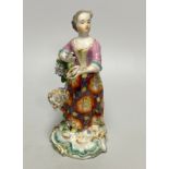 A Derby porcelain figure, emblematic of Summer, modelled as a woman wearing a floral patterned skirt