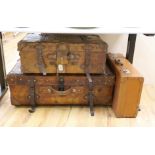 Three early 20th century brown leather cabin trunks and a later vintage suitcase, largest trunk