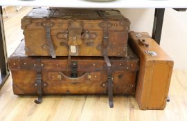 Three early 20th century brown leather cabin trunks and a later vintage suitcase, largest trunk