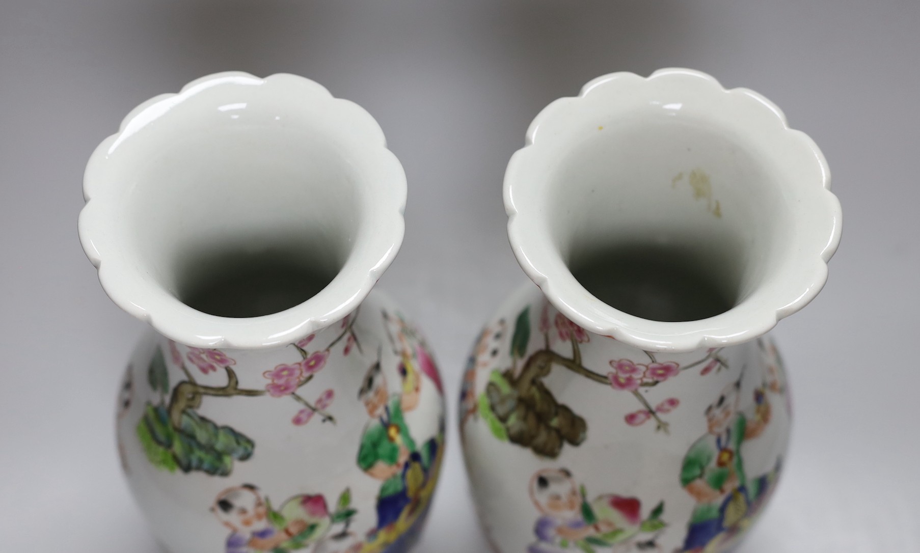 A pair of Chinese Famille Rose ‘boys’ vases, 25cms high - Image 4 of 5