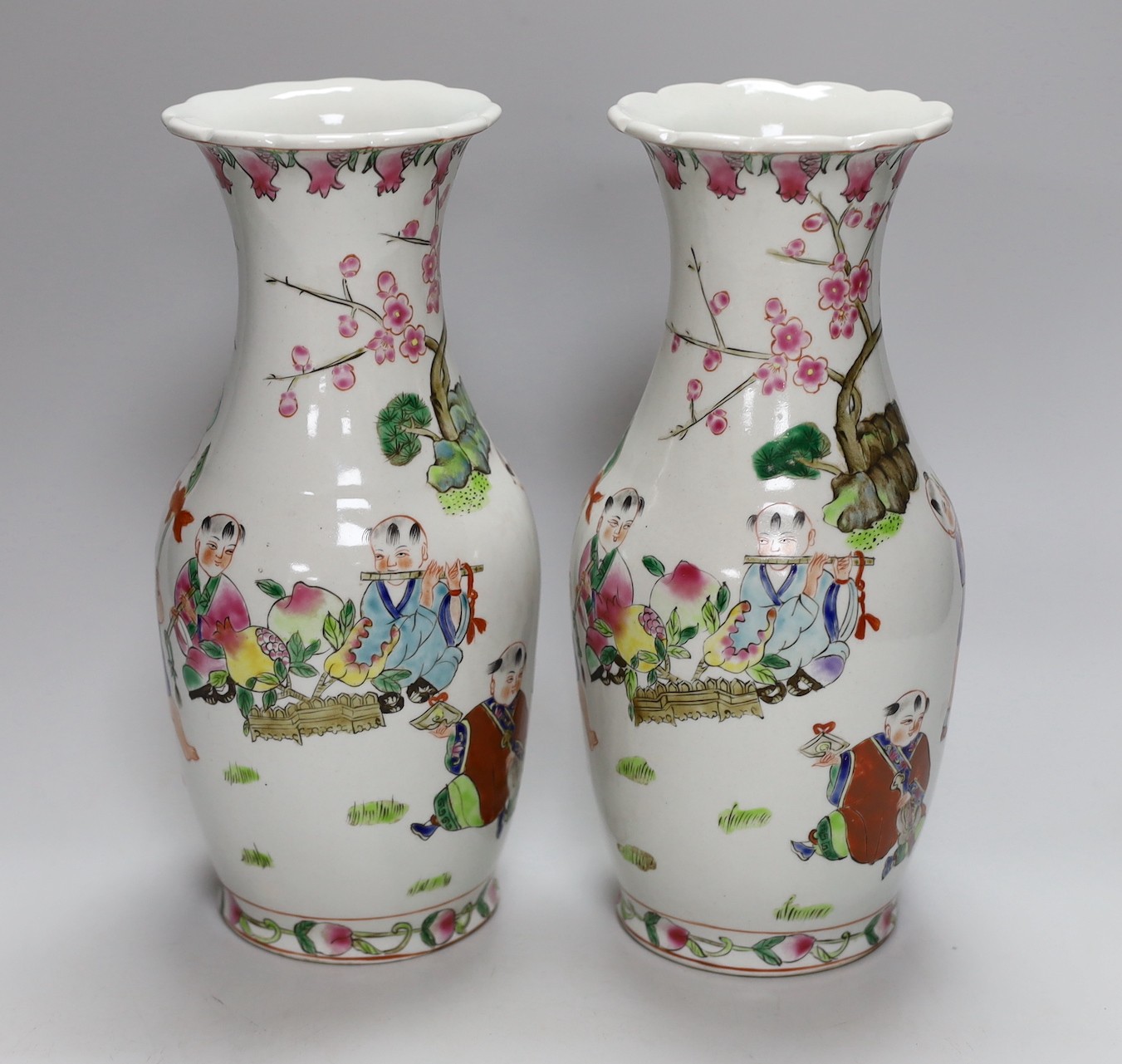 A pair of Chinese Famille Rose ‘boys’ vases, 25cms high - Image 2 of 5