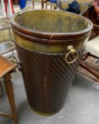 A large George III style brass mounted mahogany peat bucket, with wrythen fluted body and brass