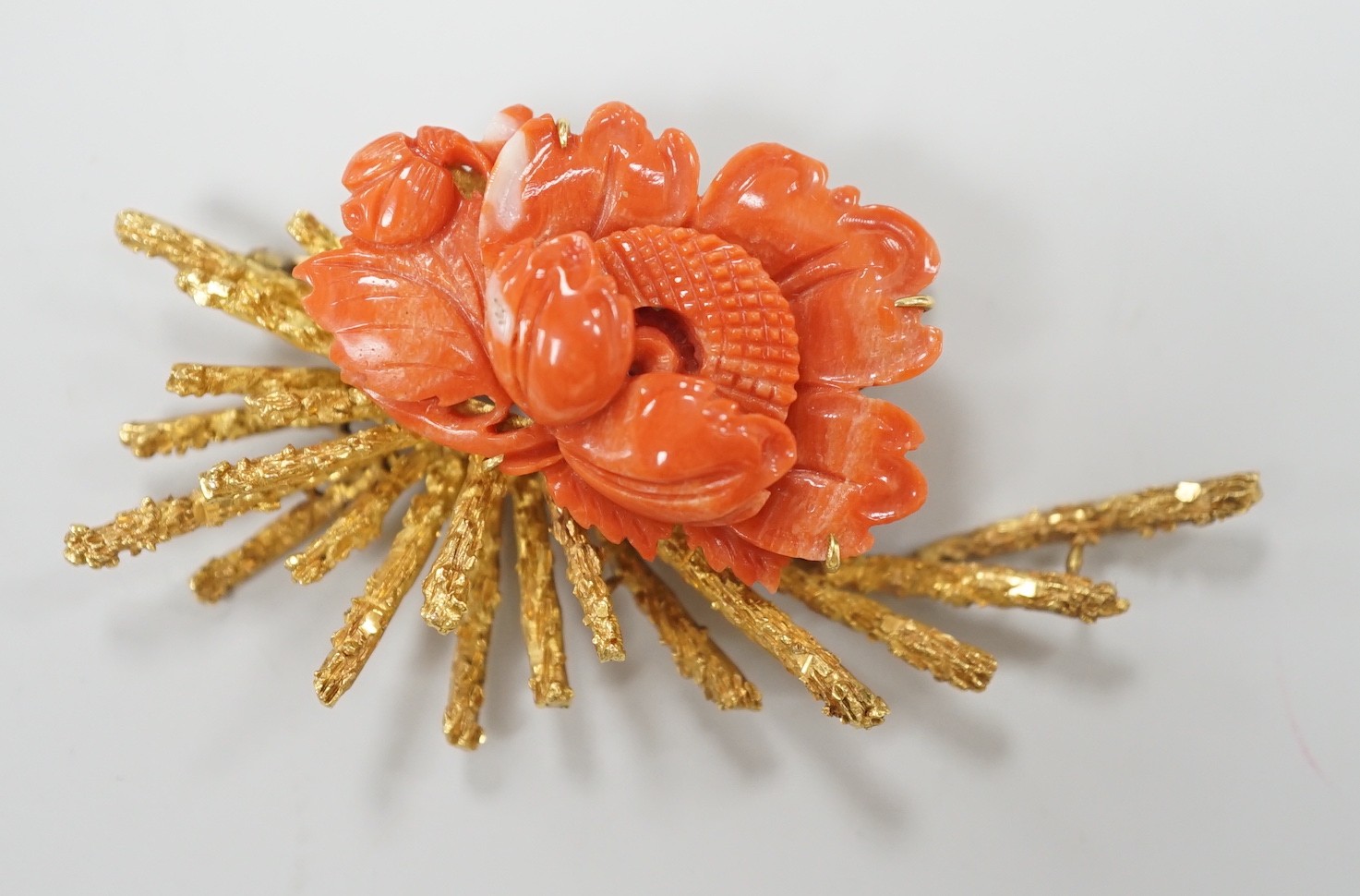 A 1970's? textured 14k yellow metal and carved coral mounted floral spray brooch, 62mm, gross weight