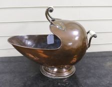 A helmet shaped copper coal scuttle, with ceramic handles, 52cms wide