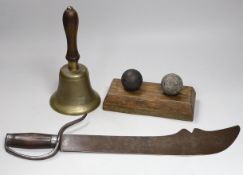 Two canon balls, a brass hand bell marked A.R.P. and a Chinese sword