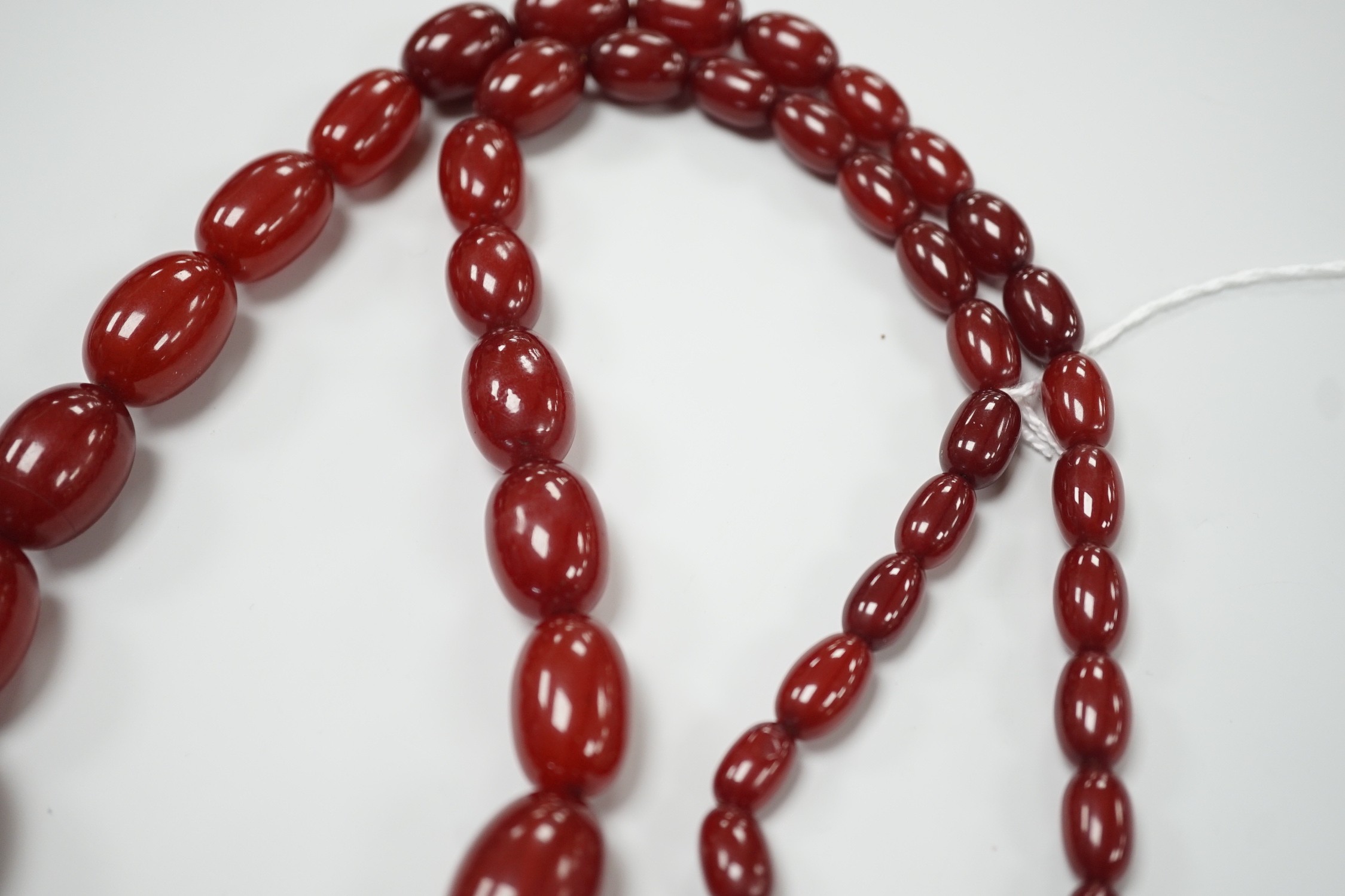 A single strand graduated simulated oval cherry amber necklace, 82cm, gross weight 113 grams. - Image 4 of 4