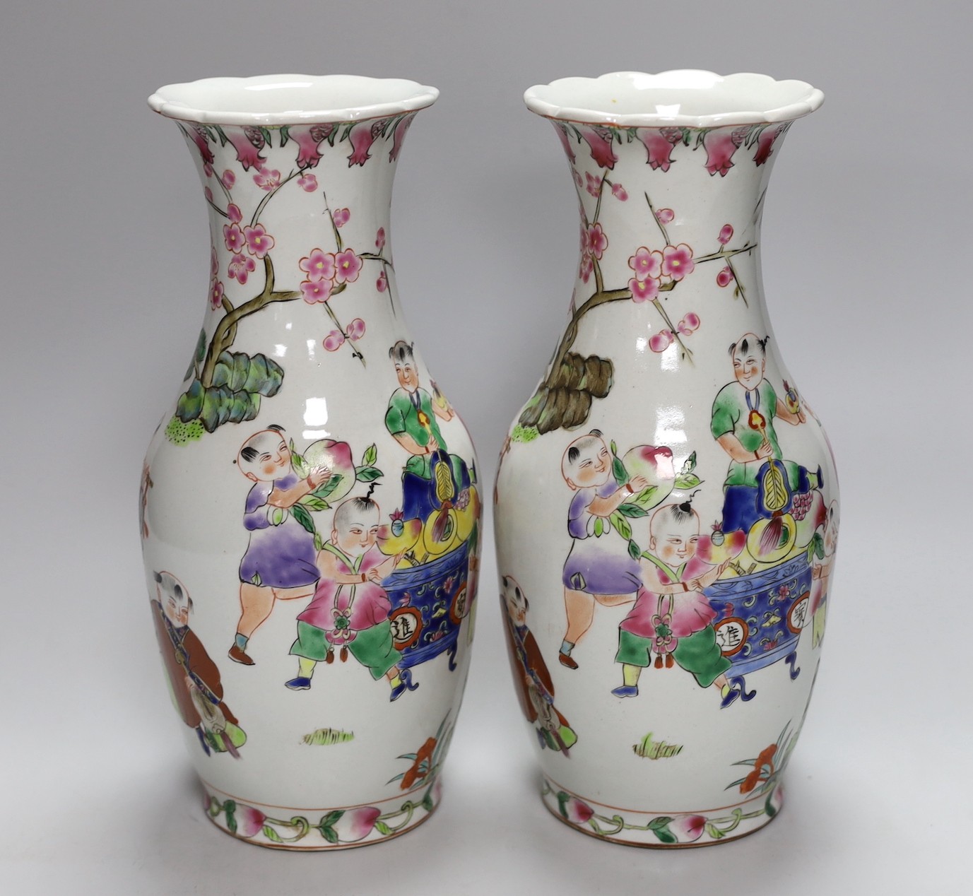 A pair of Chinese Famille Rose ‘boys’ vases, 25cms high - Image 3 of 5
