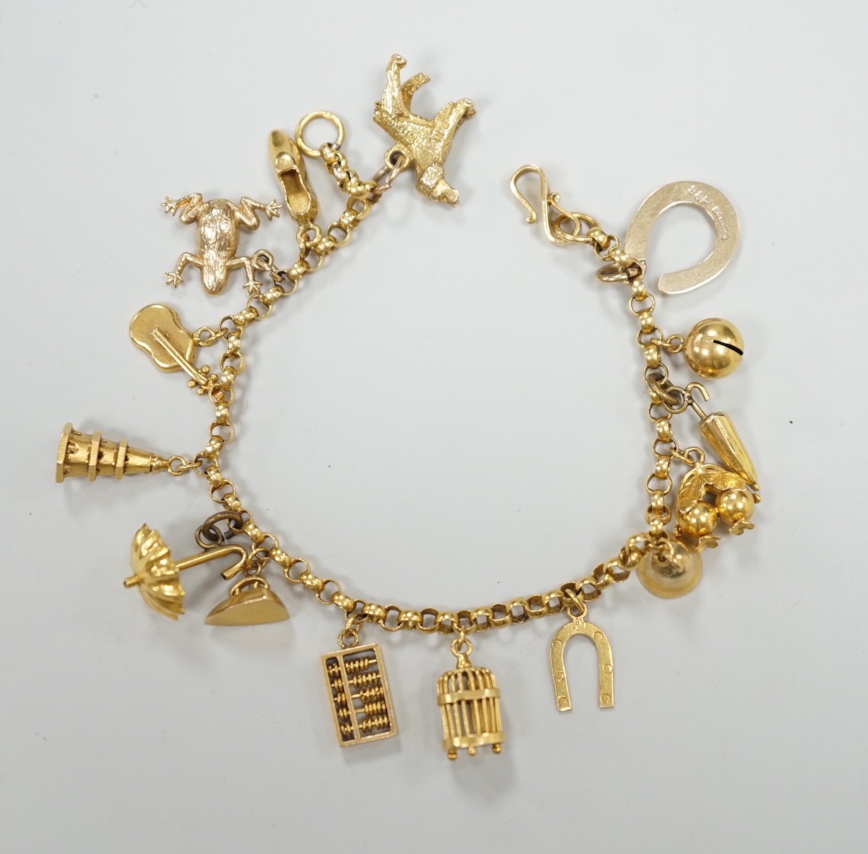 A Chinese yellow metal charm bracelet, hung with thirteen assorted yellow metal charms including