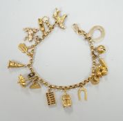 A Chinese yellow metal charm bracelet, hung with thirteen assorted yellow metal charms including