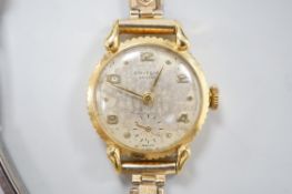 A lady's 750 yellow metal Universal manual wind wrist watch, on associated gold plated bracelet.