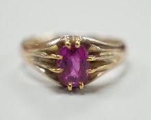 A yellow metal and claw set solitaire oval cut ruby/pink sapphire? ring, size L, gross