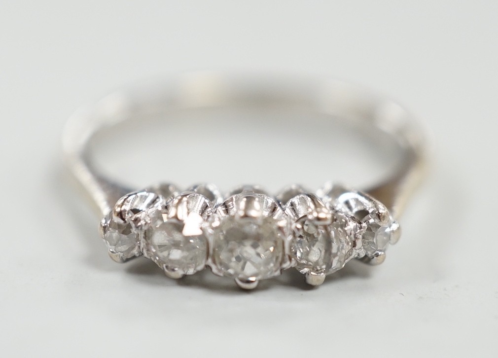 A 1970's 18ct white gold and graduated five stone diamond ring, size L/M, gross weight 3 grams.