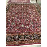 A Meshed burgundy ground carpet, signed by Akhondzadeh, 390 x 308cm